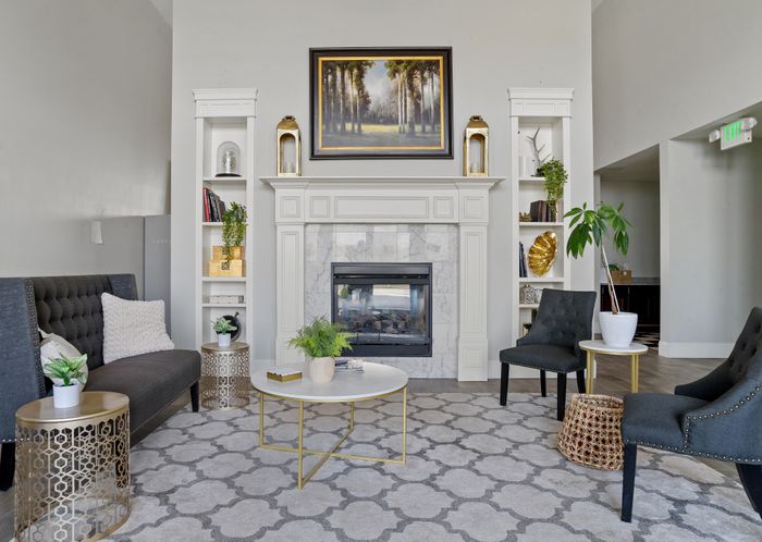 Elegant living room showcasing a modern fireplace, stylish seating, and chic decor in a cozy setting.