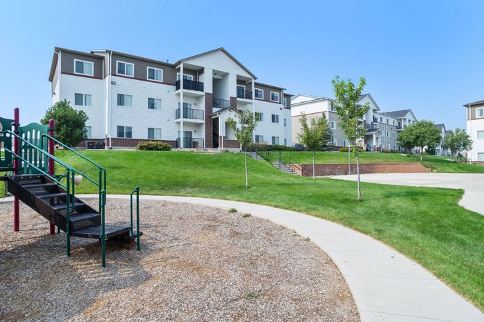 Charming residential apartment with a lush green landscape and a vibrant playground, ideal for family living.