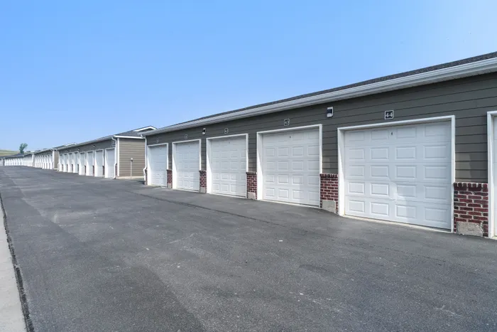 Modern apartment complex with a row of spacious and secure garages, showcasing sleek architectural design and ample parking space.