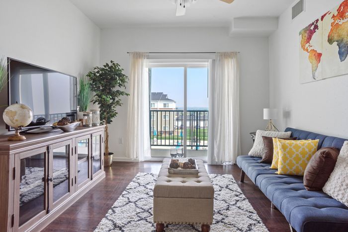 Bright and inviting living room with elegant decor, modern furnishings, and a scenic balcony view.