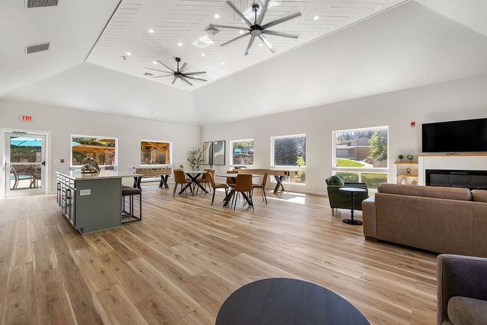 Elegant open-concept living space with modern furnishings, expansive windows, and a cozy fireplace, perfect for social gatherings.