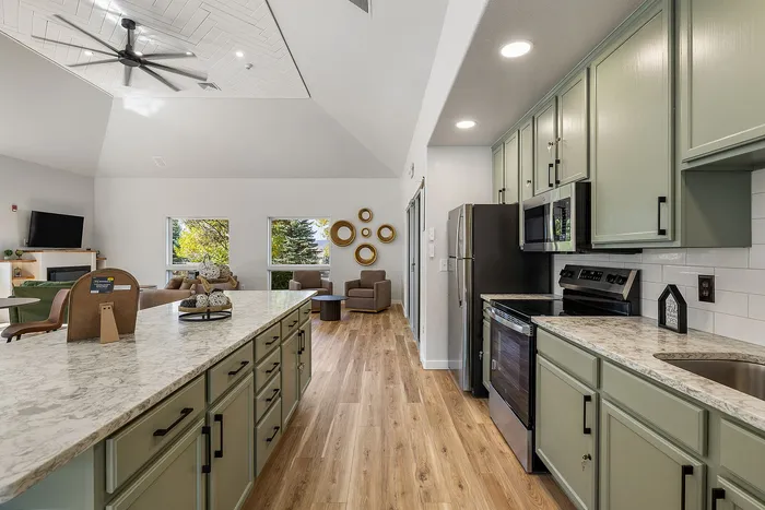 Bright and modern open-concept kitchen and living area with stylish cabinetry and sleek countertops, offering a welcoming and spacious environment.