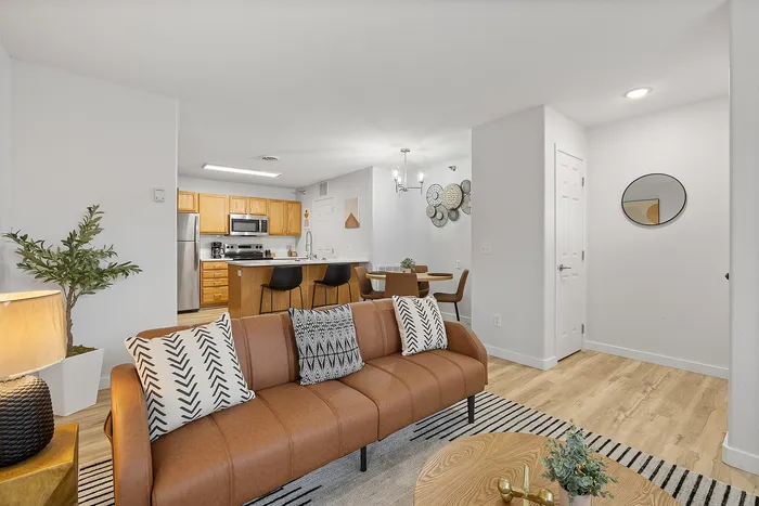 Modern open-plan apartment with a cozy living room, stylish kitchen, and elegant dining area. Featuring sleek hardwood floors, contemporary decor, and inviting natural light.