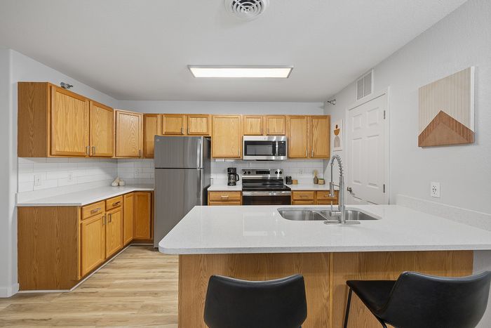 Modern kitchen with elegant wooden cabinetry, sleek stainless steel appliances, and a spacious island with a dual sink, ideal for gourmet cooking.