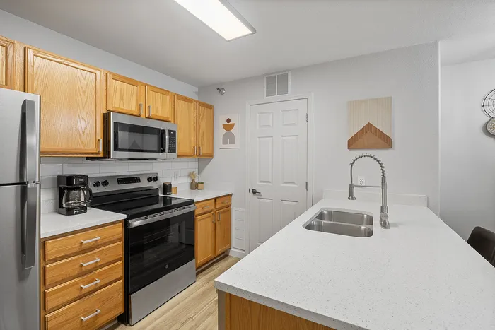 Modern kitchen featuring stainless steel appliances, sleek countertops, and warm wooden cabinetry for a stylish touch.