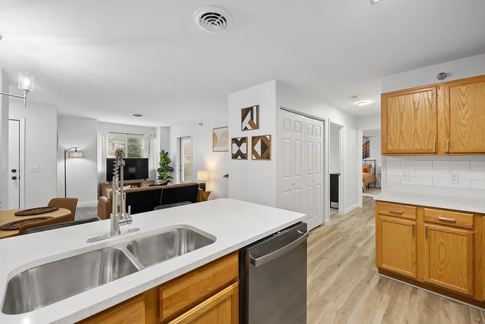 Bright and inviting open-concept kitchen and living area with modern fixtures, wood cabinetry, and cozy seating.