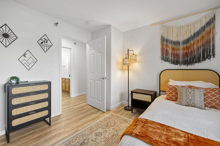 Chic bedroom with elegant decor, modern wall art, natural tones, and a cozy ambiance perfect for relaxation.