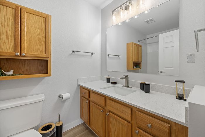 Modern bathroom featuring sleek fixtures, ample storage with wooden cabinets, and elegant lighting for a bright, inviting space.