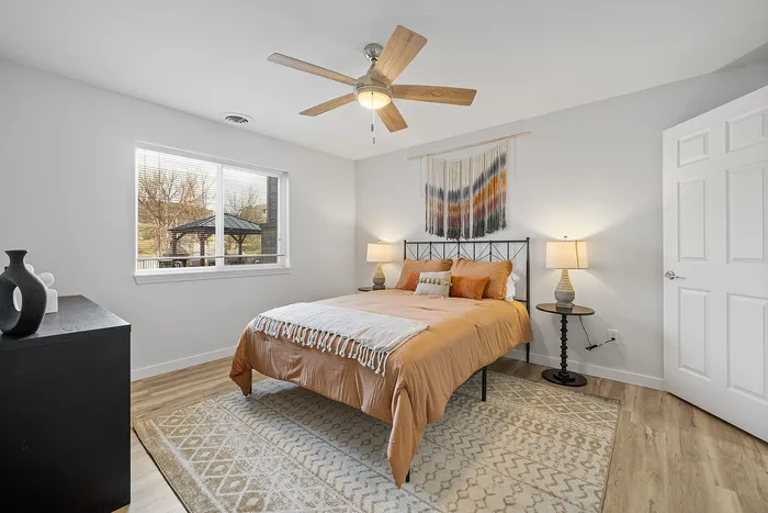 Bright and airy bedroom with a cozy bed, stylish decor, and a large window offering scenic views.