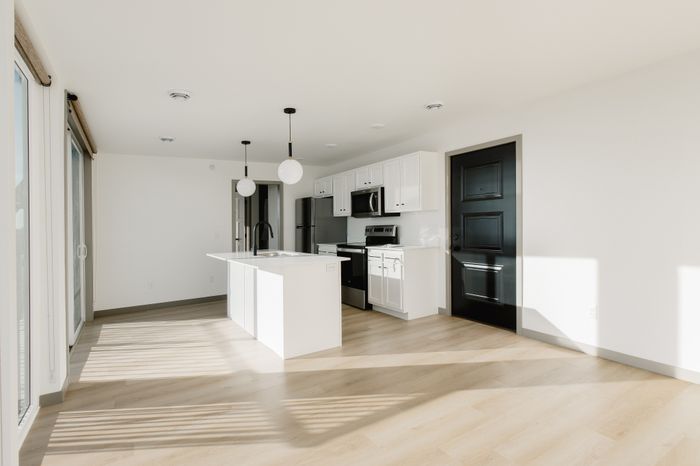 Bright and modern kitchen with sleek white cabinetry, elegant island, and stainless steel appliances, perfect for entertaining.