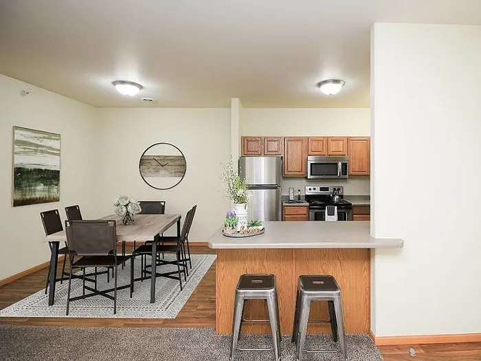 Charming open-concept kitchen and dining area with modern appliances and cozy decor, featuring a breakfast bar and elegant dining table.