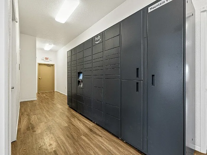 Modern apartment hallway featuring sleek Amazon Hub lockers with stylish wood flooring, ideal for convenient package delivery.