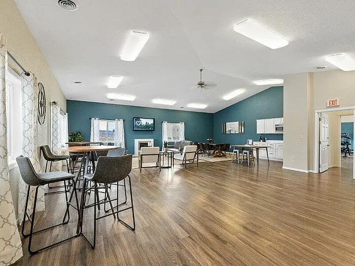 Spacious, modern living area with stylish hardwood floors, elegant lighting, and a contemporary open kitchen.