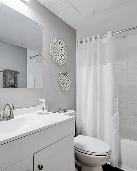 Bright and modern bathroom with sleek vanity, elegant fixtures, and relaxing white decor.