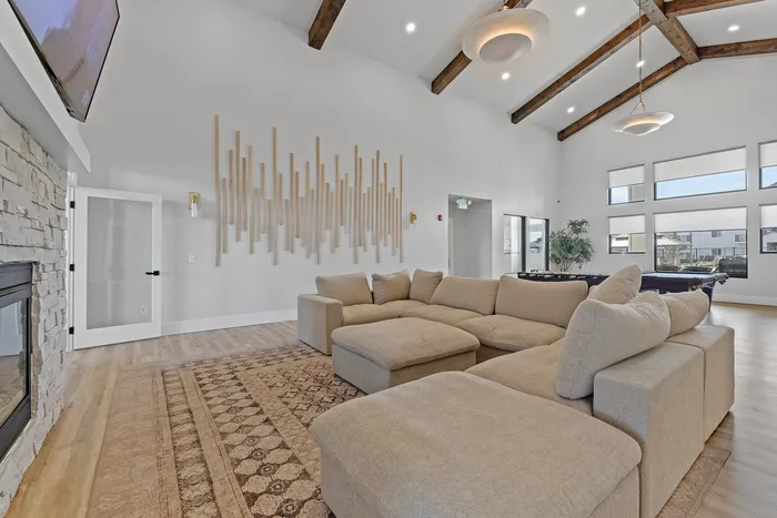Inviting living room with plush sectional sofa, high vaulted ceilings, and a modern fireplace, offering a cozy yet spacious atmosphere.