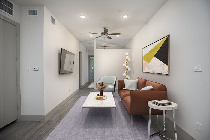 Modern living room with sleek design, featuring a leather sofa, abstract art, and minimalist furniture creating a cozy atmosphere.