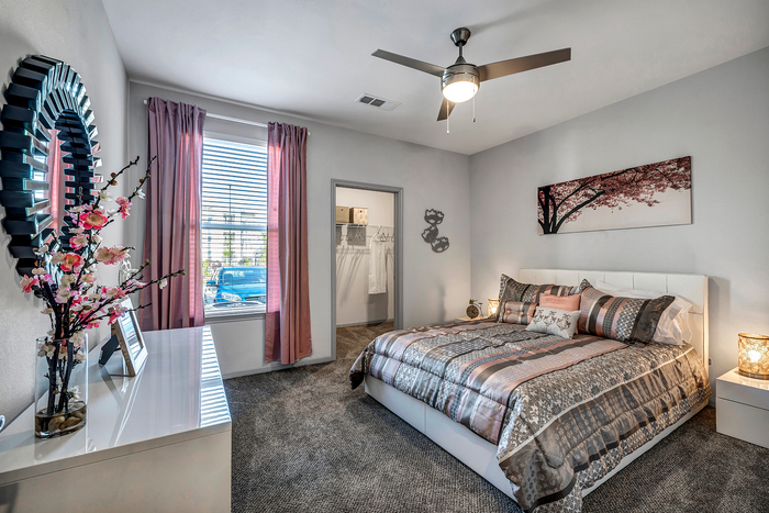 Elegant bedroom with soft lighting, stylish decor, and a plush bed, accented by floral arrangements and modern art.