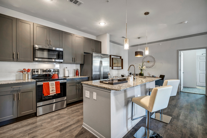 Sleek modern kitchen with granite countertops, stainless steel appliances, and stylish lighting, perfect for entertaining and culinary creativity.