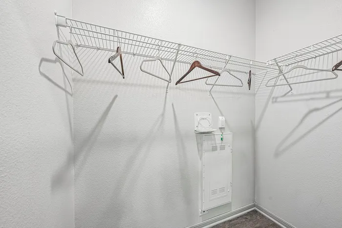 Spacious walk-in closet with sleek wire shelving and ample storage space.