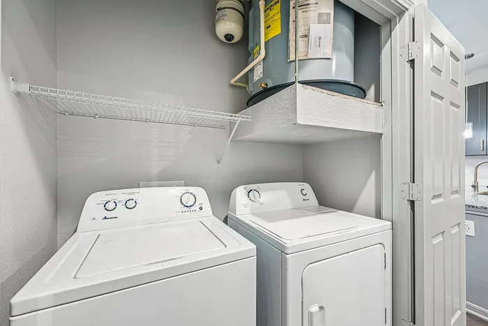 Convenient in-unit laundry room with modern washing machine and dryer, featuring ample storage space and efficient layout.