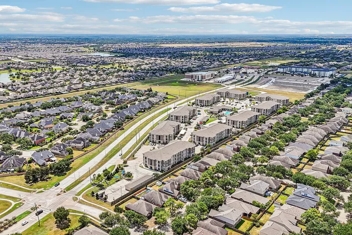 Aerial view of a modern apartment complex surrounded by scenic residential neighborhoods, offering a vibrant community atmosphere and convenient amenities.