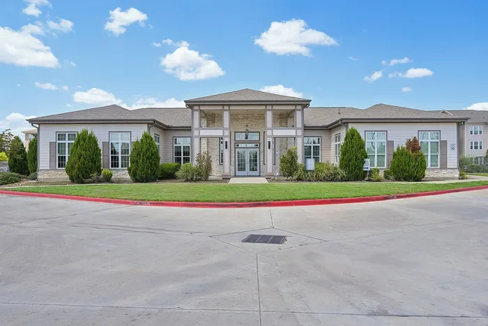 Elegant single-story building with a contemporary facade, surrounded by manicured landscaping and clear blue skies.