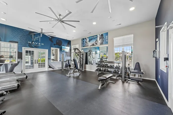 Spacious fitness center at Haven at Bellaire featuring modern workout equipment, free weights, and sleek design for an invigorating exercise experience.