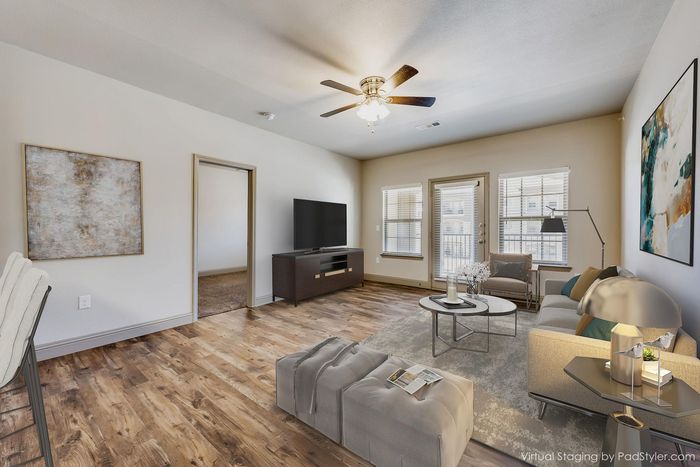 Beautifully virtual staged living room with elegant wooden floors, plush seating, and modern decor, exuding warmth and style.