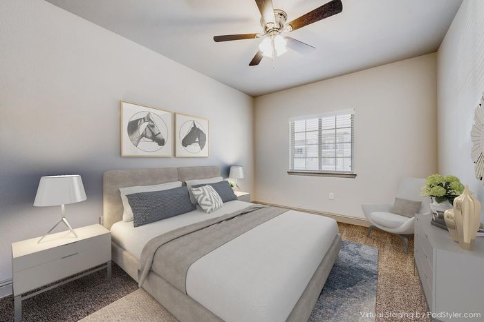 Elegant bedroom with chic decor, featuring a comfortable upholstered bed, stylish artwork, and natural light filtering through a large window.