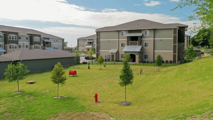 Spacious apartment complex surrounded by lush greenery and ample outdoor space, perfect for comfortable living.