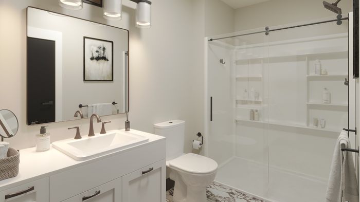 Elegant bathroom with modern fixtures, large mirror, and a glass-enclosed shower, creating a sleek and inviting space.