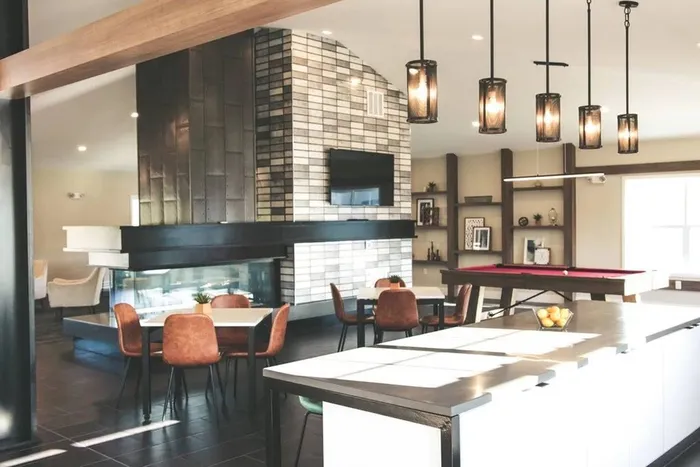 Dog-Friendly Apartments in Middletown, PA - Woodland Hills - Clubhouse with Seating Areas, Pool Table, Bar, Pendant Lights, and Wall-Mounted TV.