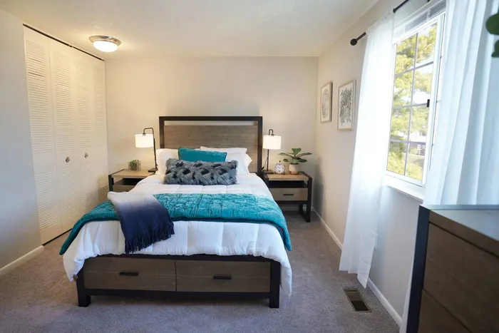 Two-BR Apartments in Jefferson Hills, PA - Heritage Hills - Furnished Bedroom with Closet, Window, and Plush Carpeted Flooring