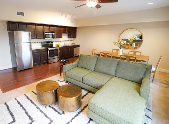 Pet-Friendly Apartments in West Chester PA - Market Street Flats - Open Living Room with Sectional Couch, Coffee Tables, Area Rug, Ceiling Fan, and View of Kitchen and Dining Room