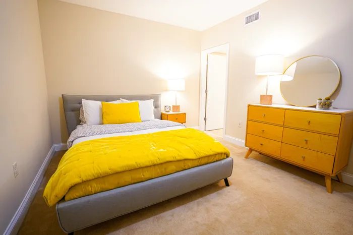 Apartments Near West Chester University - Market Street Flats - Bedroom with Plush Carpeting, Full-Sized Bed, Dresser, Nightstand and Lamps