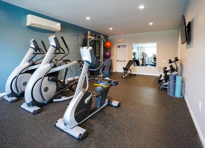 Apartments in Wilmington DE for Rent - Greenview at Chestnut Run - A Fitness Center With Multiple Cardio And Weight Machines As Well As Free Weights Next To A Large Mirror