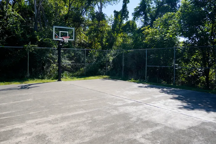 Jefferson Hills, PA Apartments For Rent - Heritage Hills - Outdoor Fenced Basketball Court Surrounded By Trees For Shade