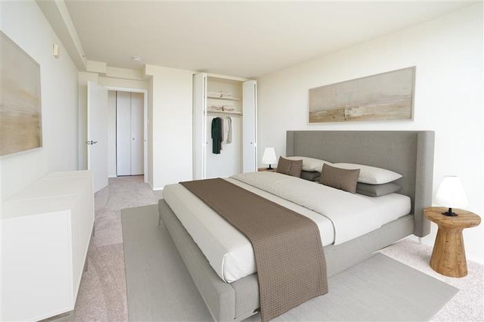 Pet-Friendly Apartments in Allentown, PA - Regency Towers - Bedroom with Carpeted Flooring, Area Rug, Full-Size Bed, Night Stands with Lamps, Wall Art, and Closet.
