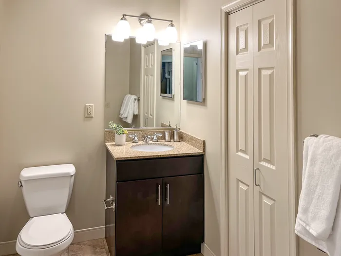 Studio Apartments in Pittsburgh - Apartments at River View - Bathroom with a Vanity Mirror, Brown Tiles, and a Cabinet