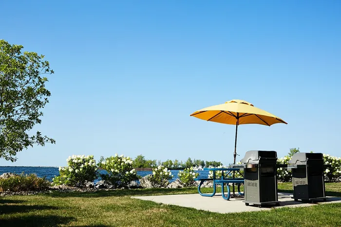 Pet-Friendly Apartments in Cleveland OH - The Shoreline - Grill Area with BBQs and Picnic Table with Umbrella.