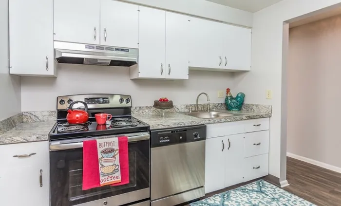 Close-up of kitchen with white cabinets and granite countertops.