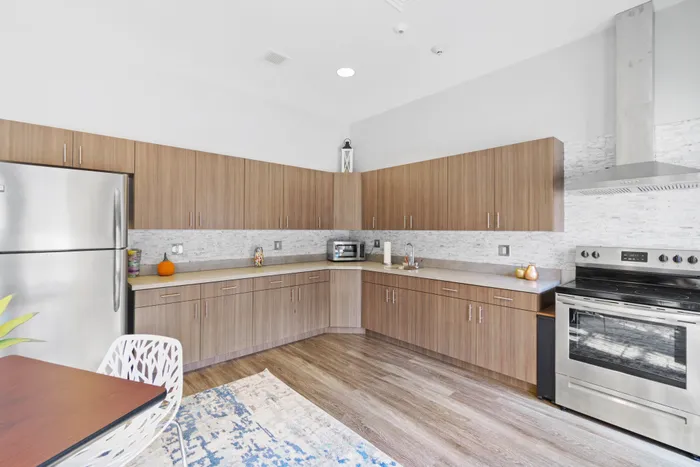 Community kitchen in the lounge of Apartments at Bel Air, featuring modern cabinets and stainless steel appliances.