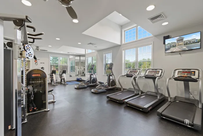 Gray fitness center at Apartments at Bel Air in Bel Air, MD with cardio and strength training equipment.