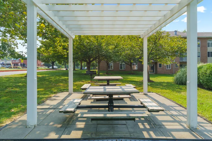 Outdoor pergola with tables and benches.
