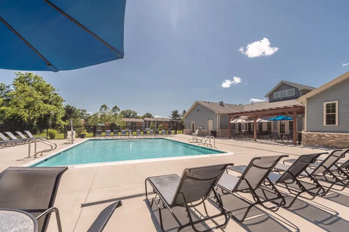 Outdoor community swimming pool at Apartments at Bel Air, surrounded by deck chairs.