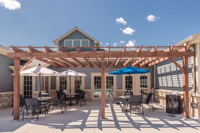Outdoor wooden gazebo with patio tables and chairs by the community swimming pool at Apartments at Bel Air in Bel Air, MD.