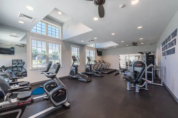 Spacious fitness studio with various exercise equipment and weight training stations.