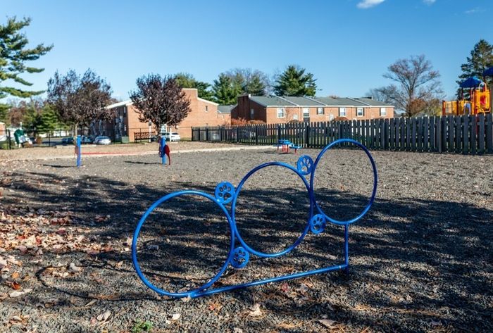 2-Bedroom Apartments in Bensalem, PA - Village Square - Fenced Outdoor Dog Park with Agility Course and Nearby Trees.