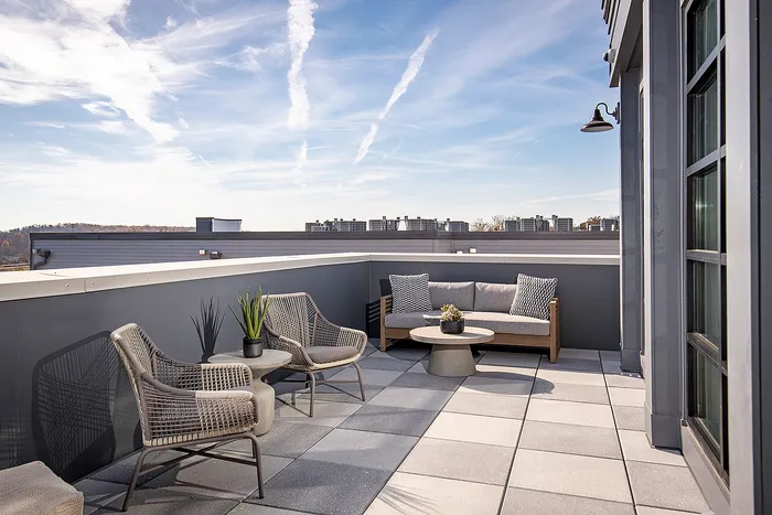 Modern rooftop terrace with stylish furniture and cityscape views, perfect for relaxation.