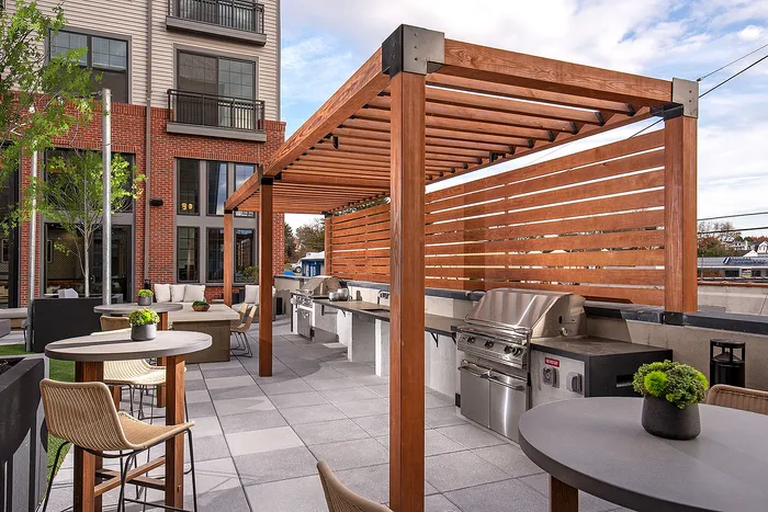 Beautiful outdoor patio with modern pergola, stylish seating, and a built-in barbecue area.